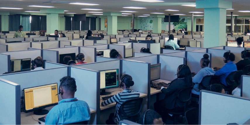 A large room of cubicles with agents seated in each cubicle answering phone calls.
