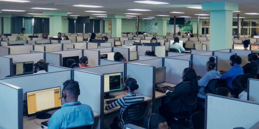 Image of cubicles across a large room with customer service agents in each cubicle.